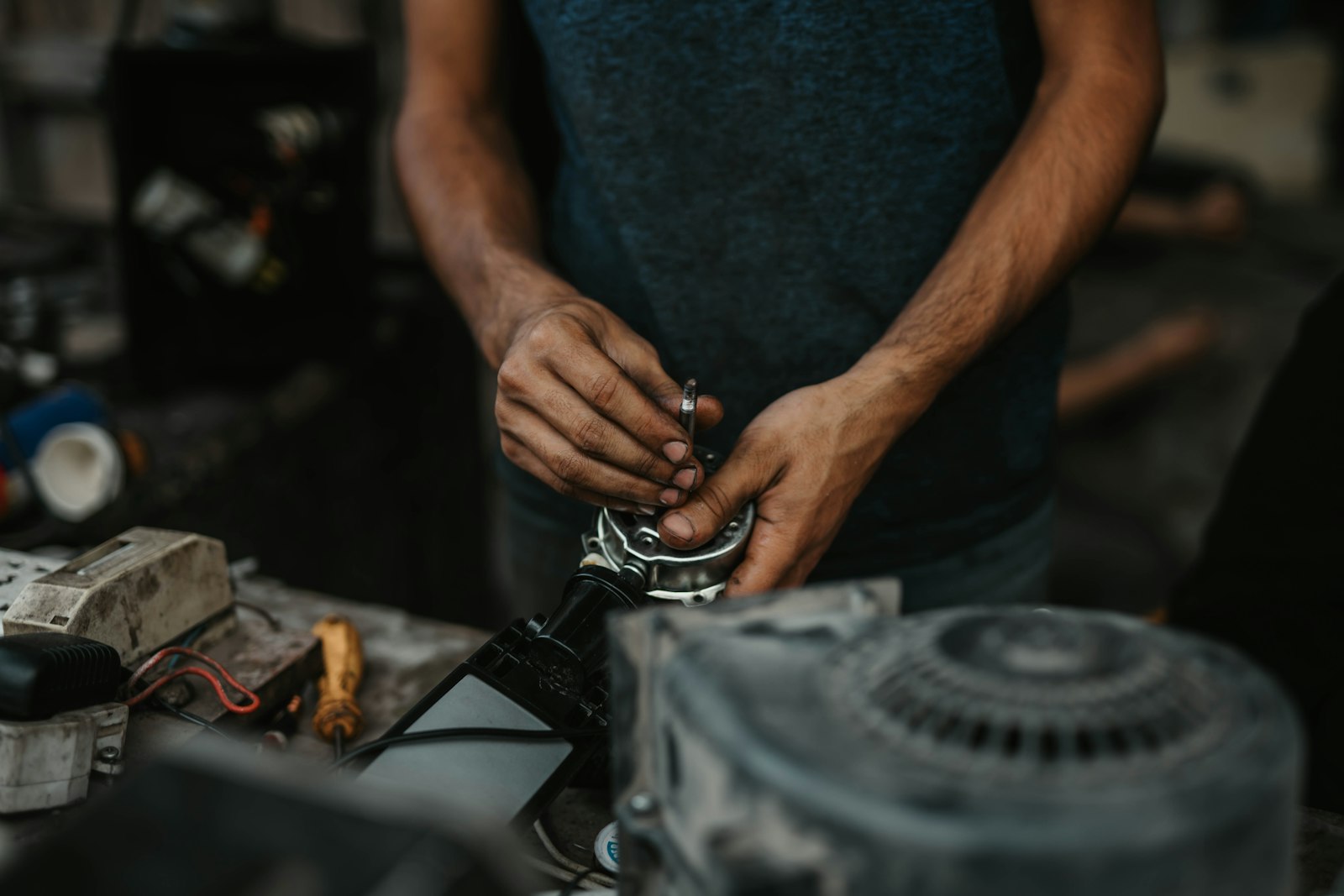 Repair technician holding a metal tool over an appliance component