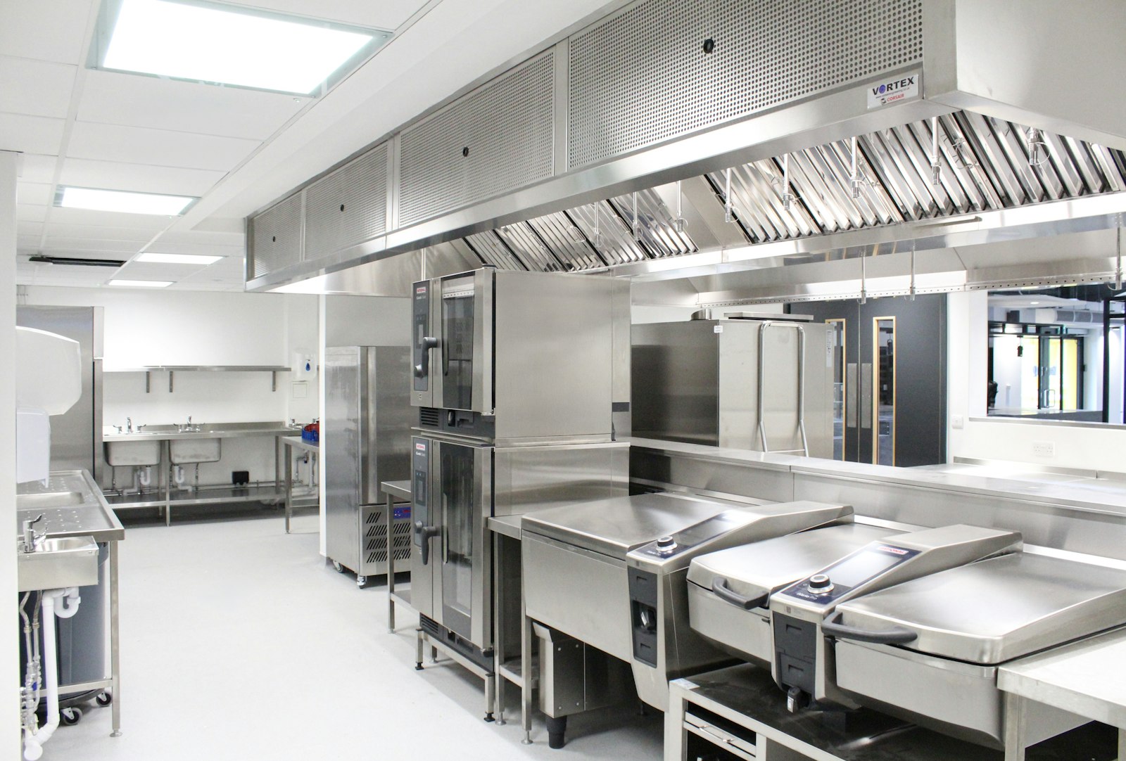 Commercial restaurant kitchen with stainless steel refrigeration and prep equipment