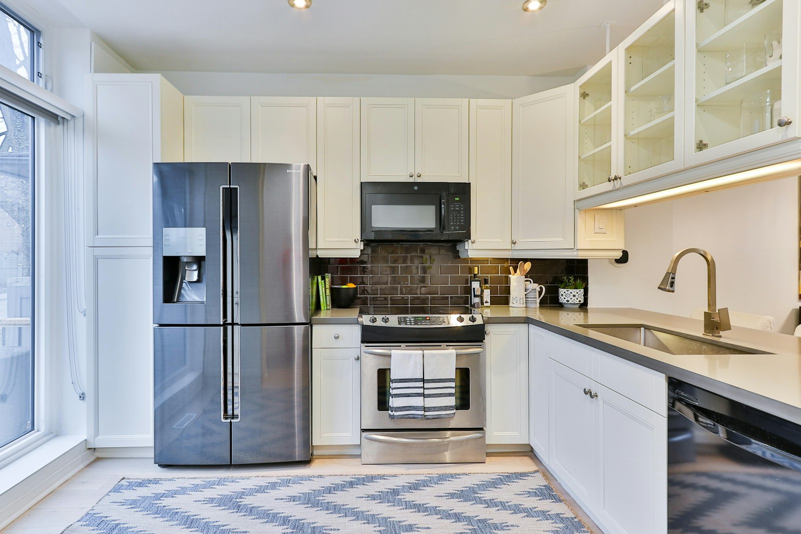 Silver French-door refrigerator beside white kitchen cabinets