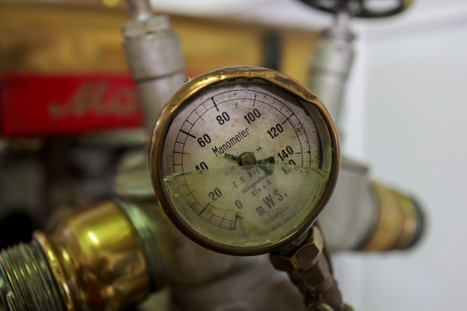 Close-up of a pressure gauge attached to a copper refrigerant pipe