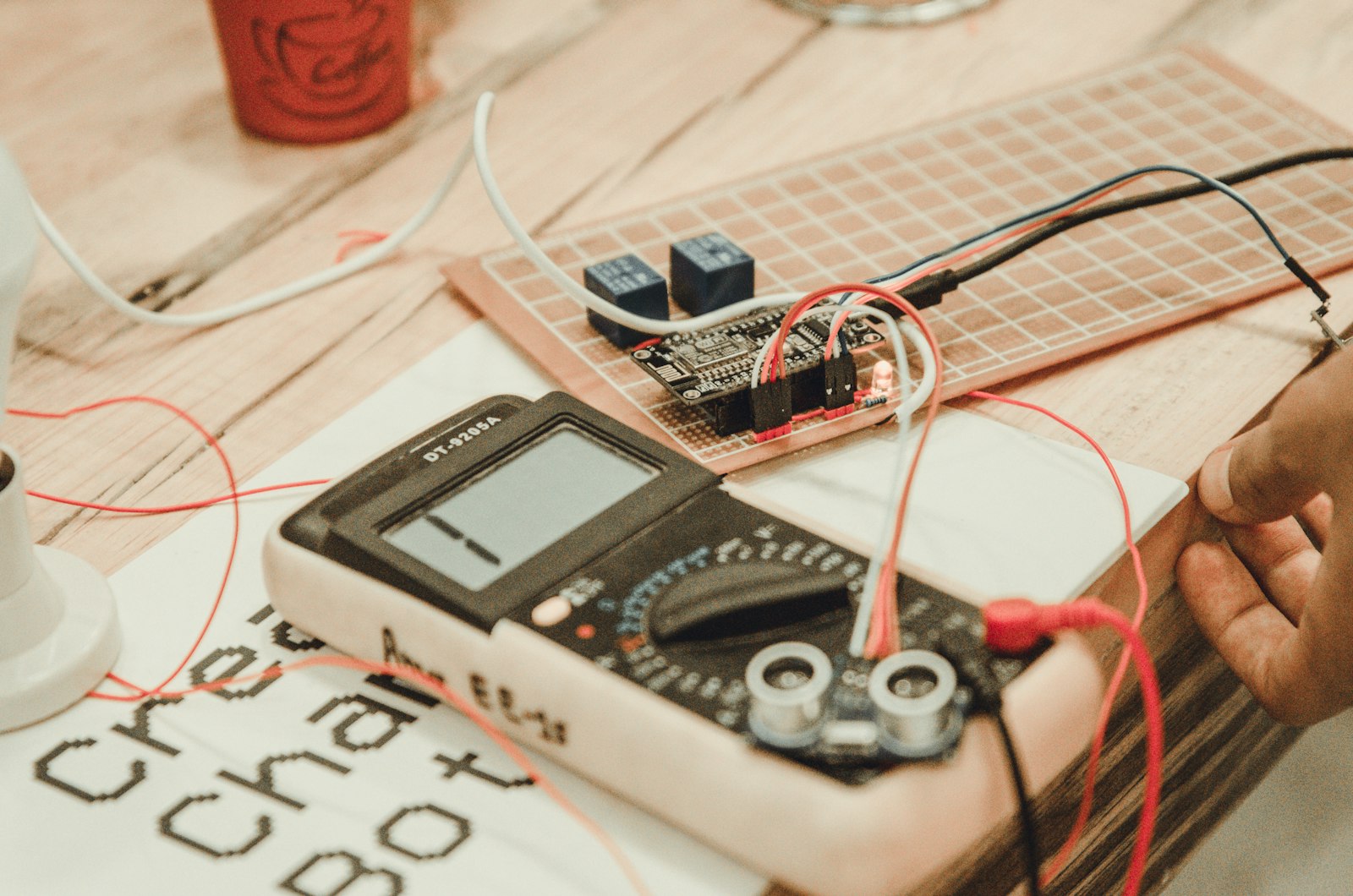 Technician measuring a circuit with a white digital multimeter