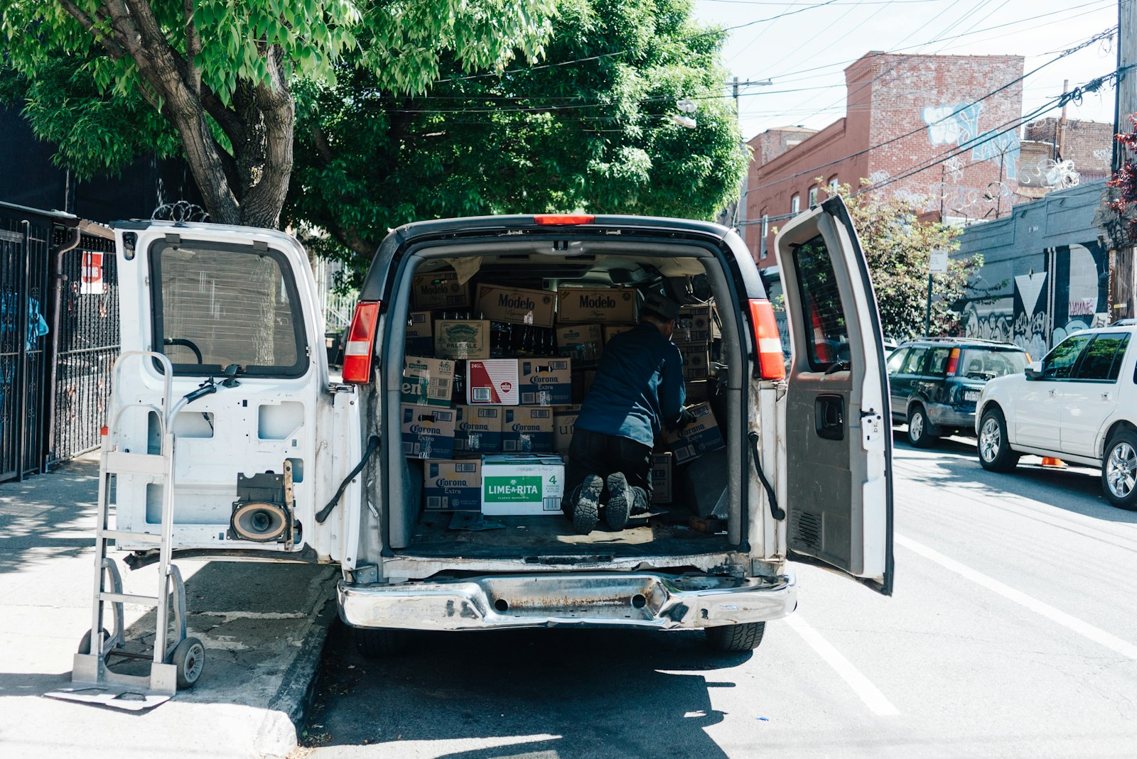 White service van parked on a city street with its side door open
